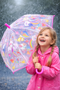pige med lyserød børneparaply hvor farver og motiver ændrer sig når det regner